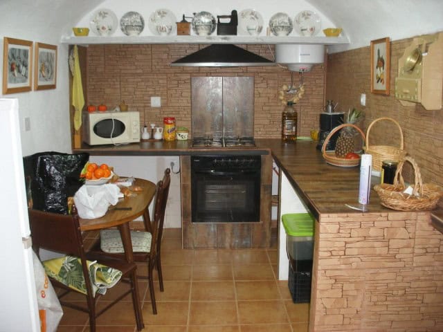 Charming cave house kitchen in Cortes de Baza, Granada, featuring rustic decor and modern appliances.