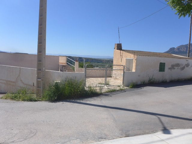 Cave house in Cortes de Baza, Granada, featuring rustic walls and scenic mountain views.