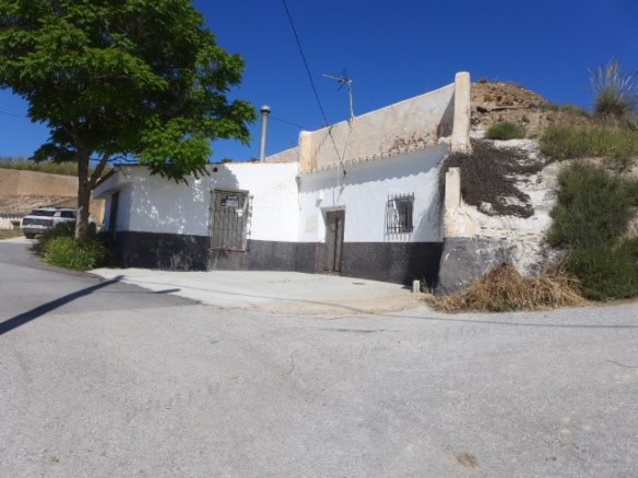 Traditional cave house in Cortes de Baza, Granada, with whitewashed walls and rustic charm.