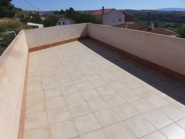 Balcony of Cave House with tiled floor and scenic mountain views.
