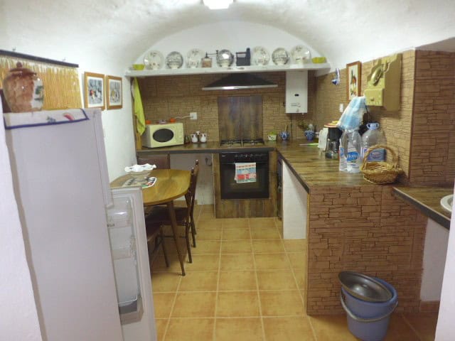 Charming cave house kitchen in Cortes de Baza, Granada, with rustic decor and modern appliances.
