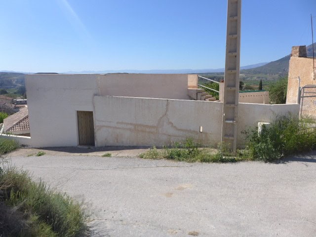 Cave house in Cortes de Baza, Granada, with whitewashed walls and scenic mountain views.