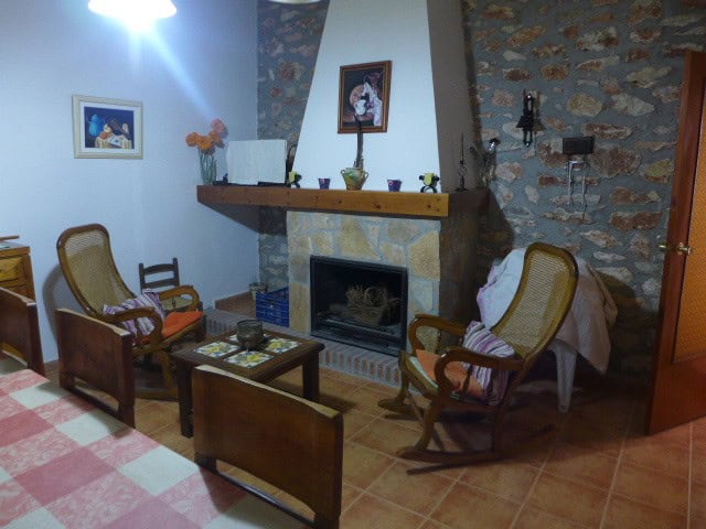 Charming cave house interior with stone walls, wooden furniture, and a fireplace in Cortes de Baza,.