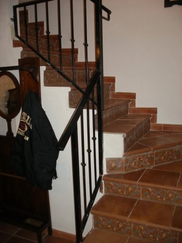 Interior staircase of a village property in Benamaurel, Granada, featuring terracotta tiles and wrou.