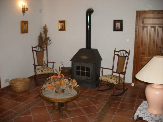 Charming village home interior in Benamaurel, Granada featuring a wood stove and vintage furniture.