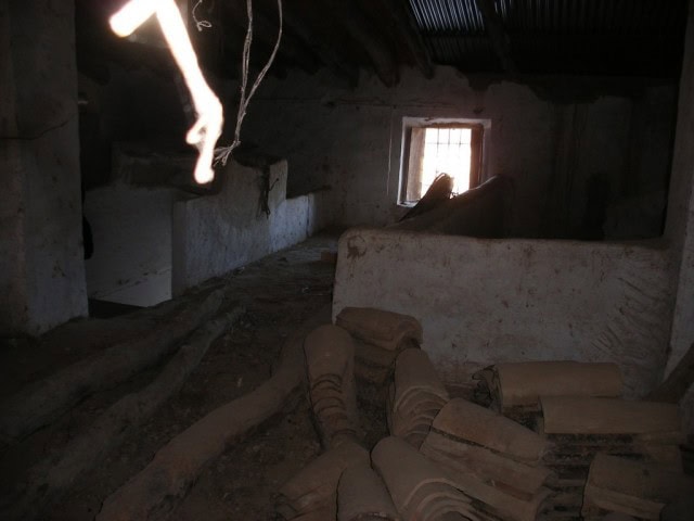 Interior of a rustic village property in Venta del Peral, Granada, showing aged walls and wooden bea.