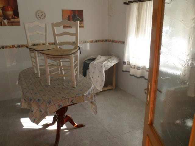 Charming village home interior with a cozy dining area and natural light from window.