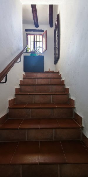Charming interior staircase of a village property in Cuenca, Jaen, with rustic wooden beams and a wi.