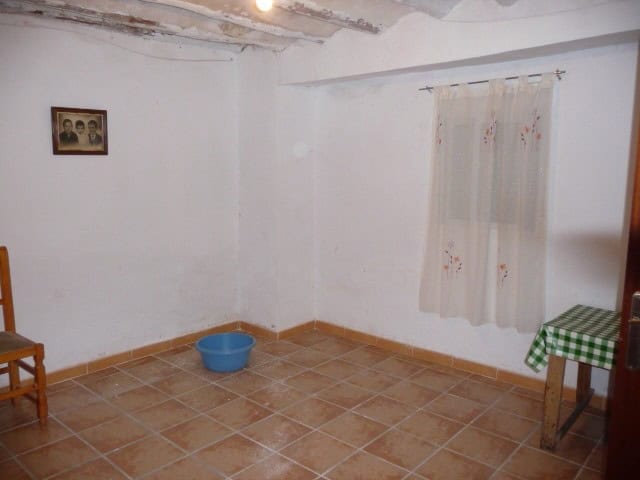 Interior of a rustic village property in Huesa, Jaen with simple furnishings and white walls.