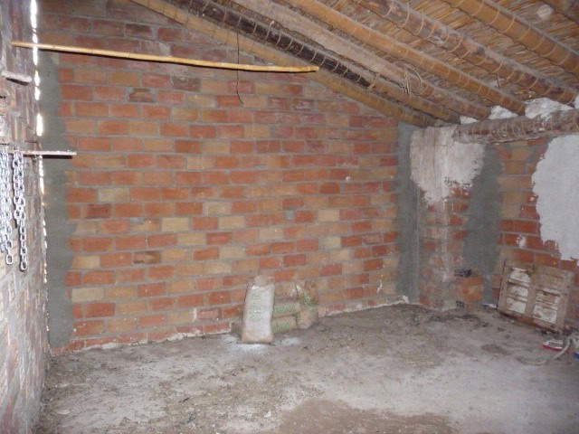 Spacious interior of a village property in Huesa, Jaen, showing brick walls and unfinished flooring.