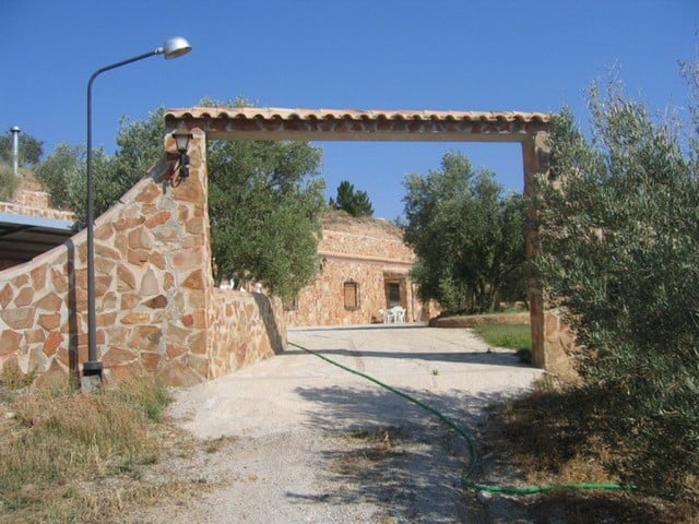 Farm property in Cullar, Granada with scenic views and traditional stone entrance.