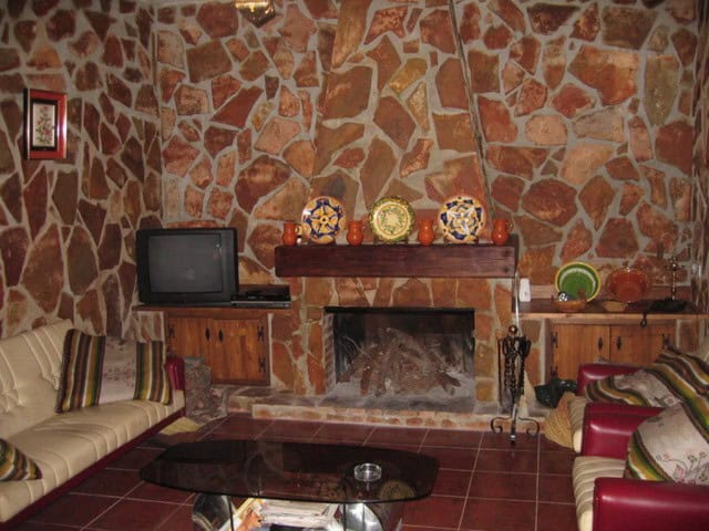 Farmhouse living room with stone walls and traditional decor in Cullar, Granada.