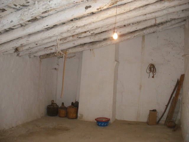 Traditional rural property interior in Velez Blanco, Almeria, with rustic beams and simple furnishin.