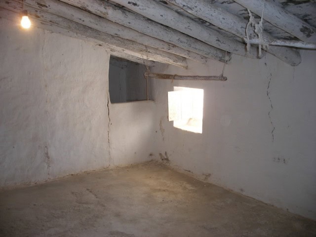 Interior of rustic rural property in Velez Blanco, Almeria with white walls and exposed wooden beams.