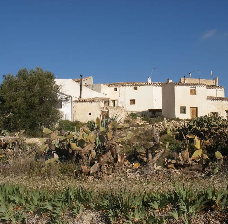 Rural property in Velez Blanco, Almeria, featuring whitewashed buildings and surrounding desert land.