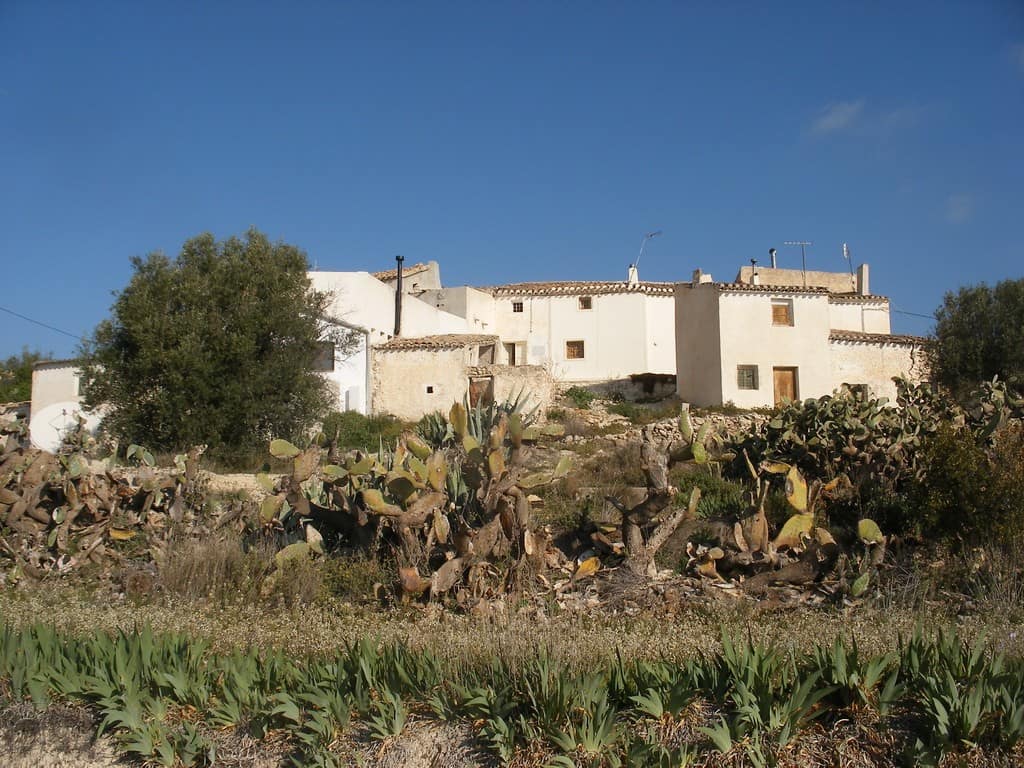 Rural property in Velez Blanco, Almeria, featuring whitewashed buildings and surrounding desert land.