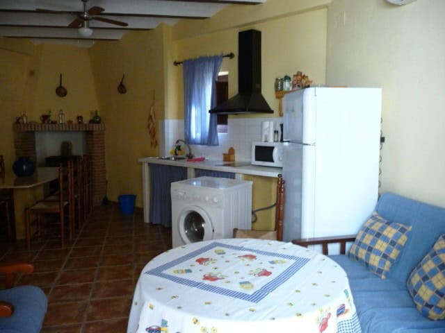 Cozy interior of a village property in Belerda, Jaen, featuring a kitchen and living area with tradi.