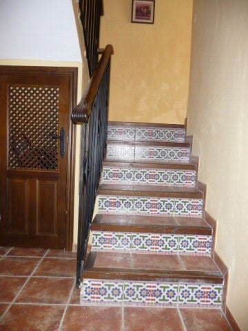 Charming interior staircase with colorful tile risers in Belerda, Jaen village property.