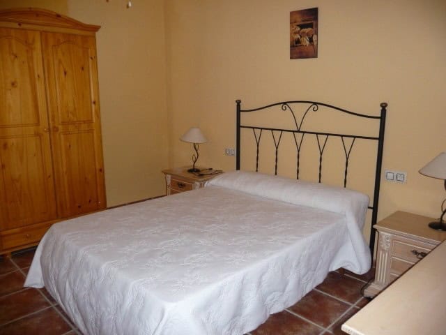 Village Property Bedroom in Belerda, Jaen with rustic furniture and cozy ambiance.