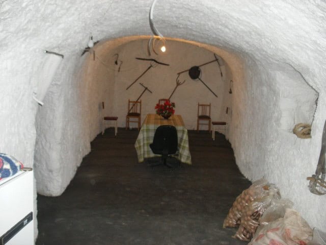 Cave house interior with rustic furniture and unique wall decor in Cuevas del Campo, Granada.