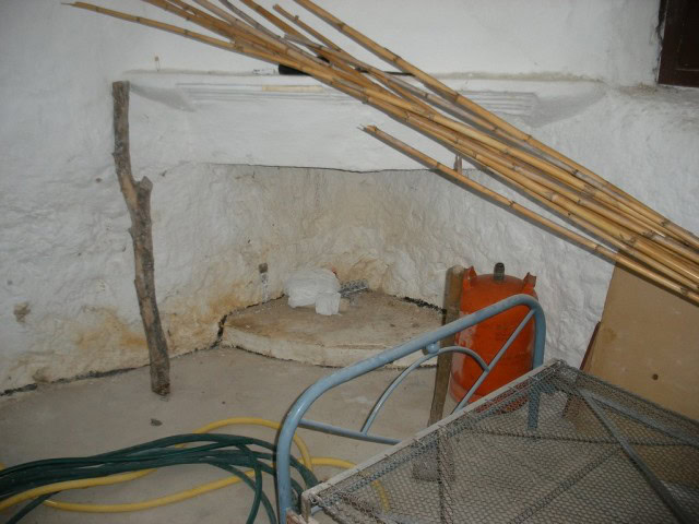 Traditional cave house interior in Cuevas del Campo, Granada, showing rustic walls and construction.