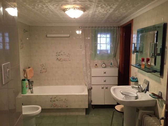 Bathroom with bathtub, sink, and mirror in a village property in Orce, Granada.