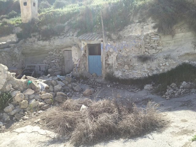 Cave house with blue door in Galera, Granada, built into a hillside.