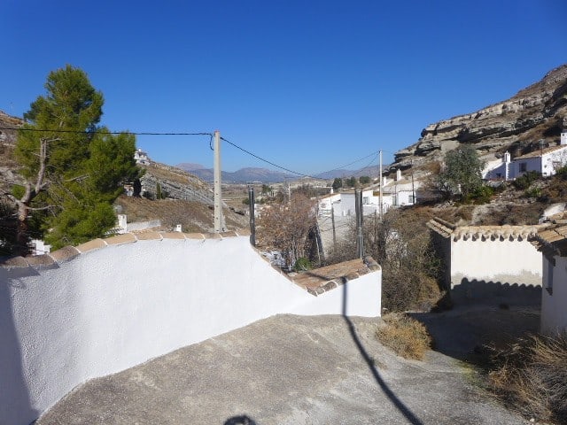 Cave house in Galera, Granada with white walls and scenic mountain views.