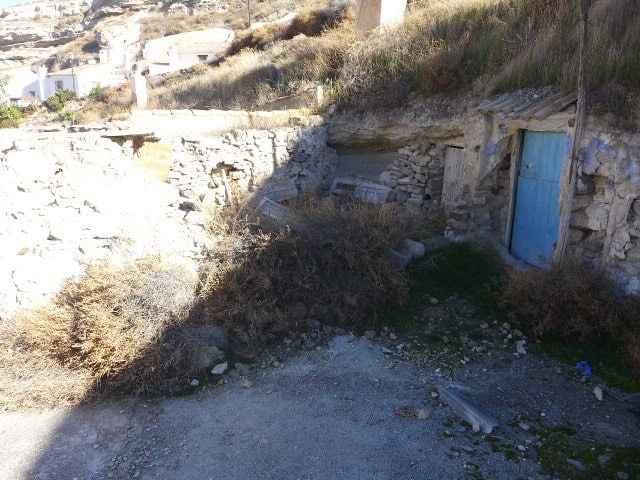 Cave house with blue door in Galera, Granada, built into the hillside. Rustic and charming property.