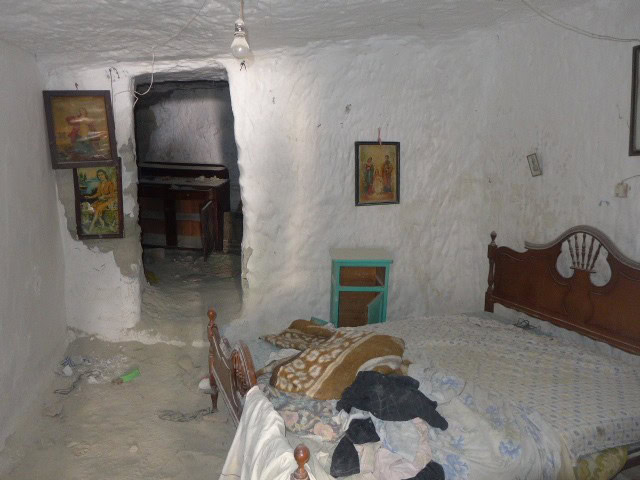 Cave house interior with rustic furniture and artwork in Galera, Granada. Unique living space built.