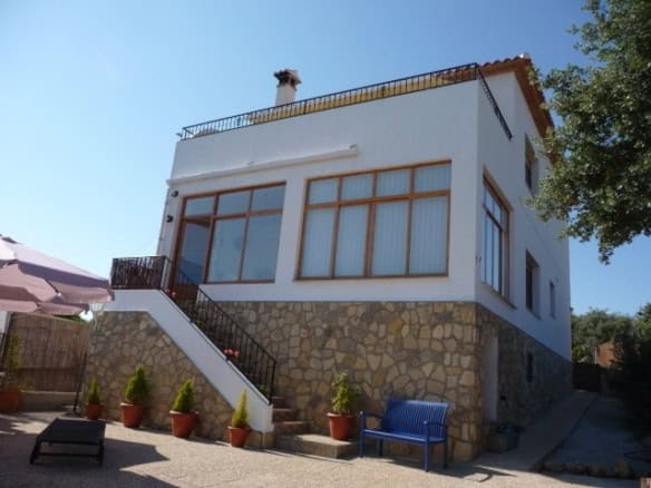 Rural property in Castril, Granada featuring a modern white exterior, large windows, and scenic surr.