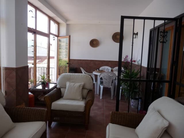 Bright living room with large windows and comfortable seating in rural Castril, Granada.