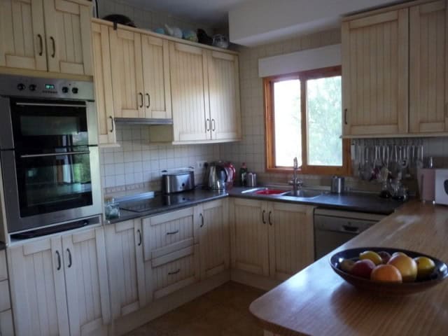 Rural property kitchen with wooden cabinets and modern appliances in Castril, Granada.
