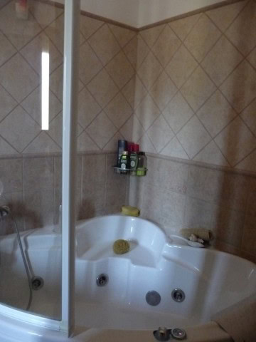 Bathroom with Jacuzzi tub, shower, and toiletries in a rural property in Castril, Granada.