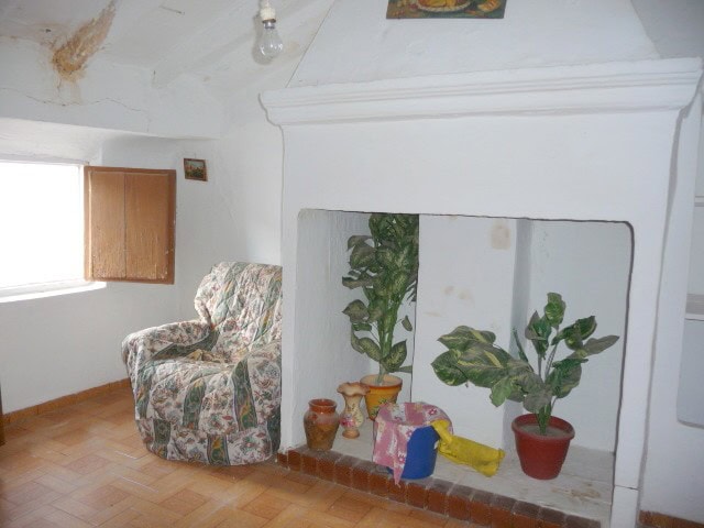 Cozy interior of a traditional village house in Belerda, Jaen, featuring a comfortable armchair and.
