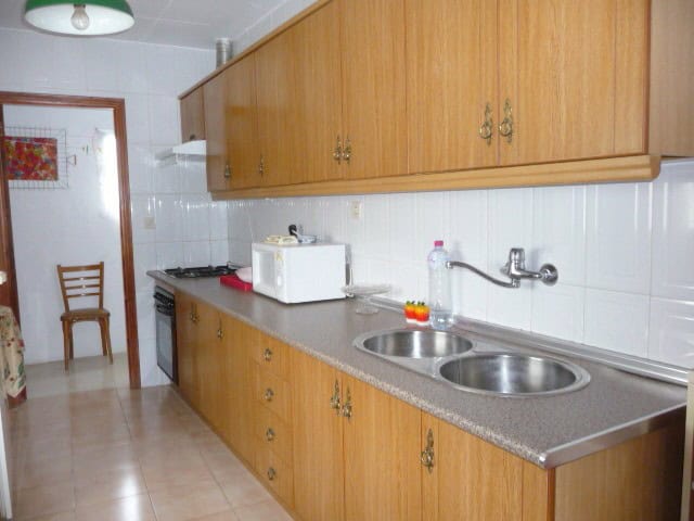 Charming village home kitchen in Belerda, Jaen with wooden cabinets and modern appliances.