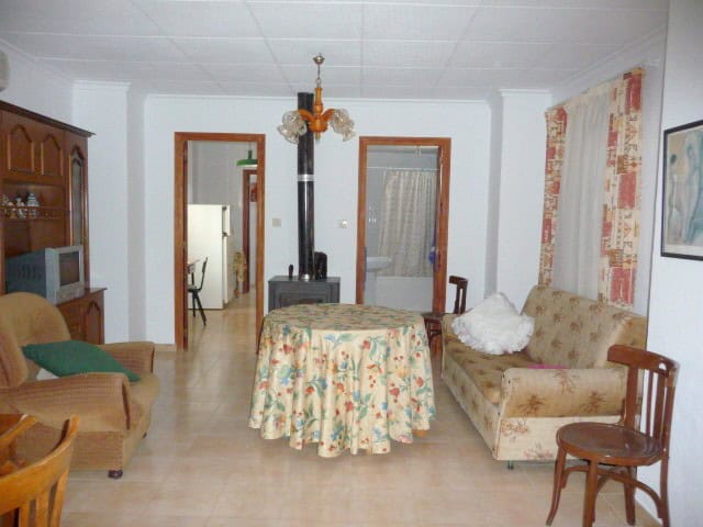 Charming living room of a village property in Belerda, Jaen, featuring vintage furniture and a wood.