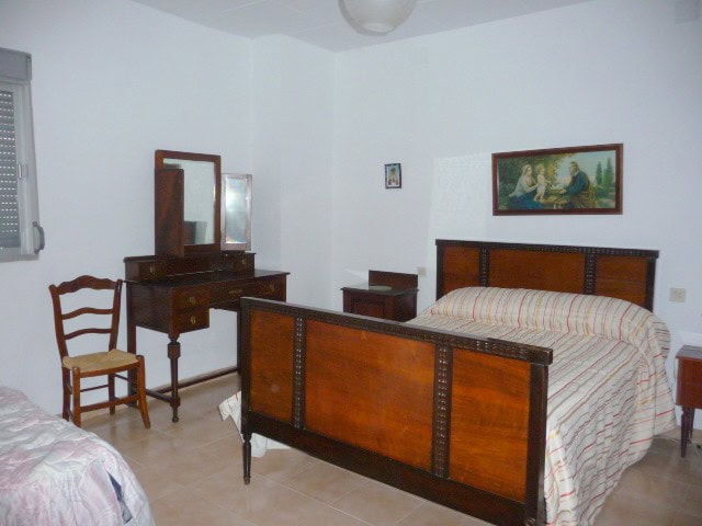Cozy bedroom with wooden furniture in a village property in Belerda, Jaen, featuring a large bed, dr.