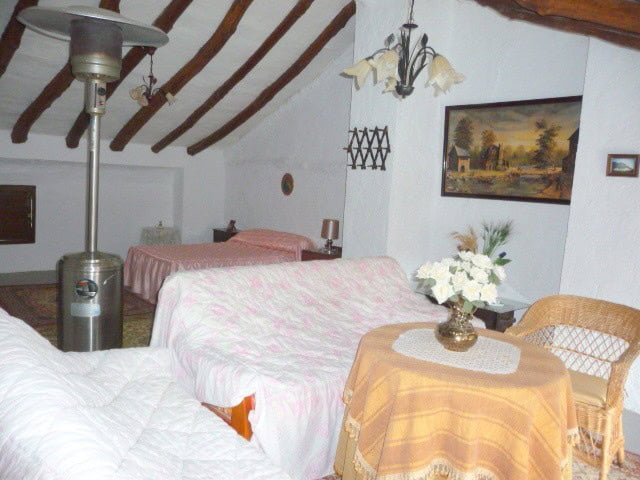 Charming village house interior with rustic wooden beams and cozy furnishings in Belerda, Jaen.