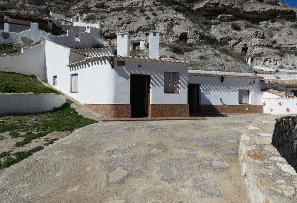 Cave house in Galera, Granada with white walls and rustic exterior.