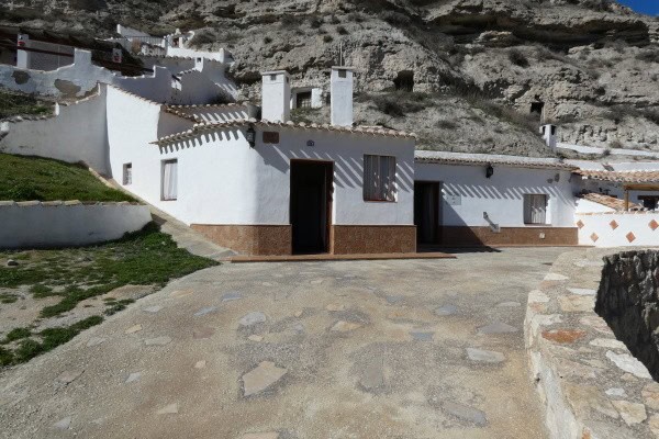 Cave house in Galera, Granada with white walls and rustic exterior.