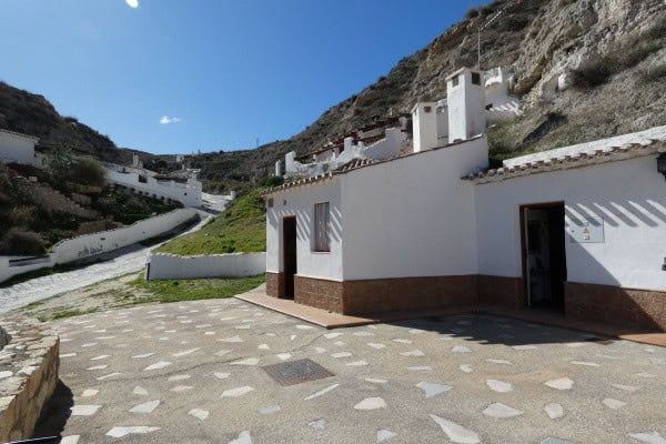 Cave house in Galera, Granada with white walls and mountain backdrop.