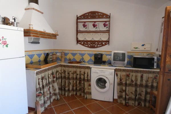 Cozy cave house kitchen with traditional decor in Galera, Granada, featuring a washing machine and v.