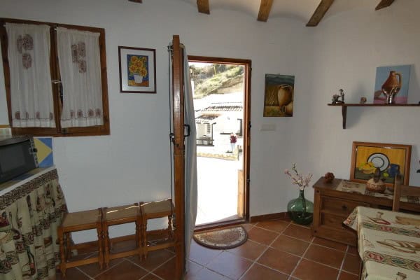 A cave house in Galera, Granada, featuring rustic interior with wooden beams, decorative art, and a.