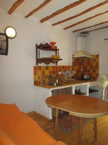 Charming village property kitchen in Quesada, Jaen with rustic wooden beams and colorful tiled backs.
