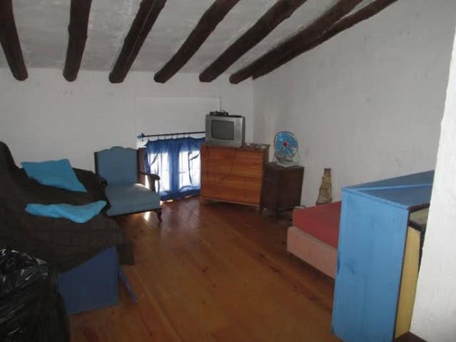 Cozy interior of a village property in Quesada, Jaen, featuring rustic wooden beams and simple furni.