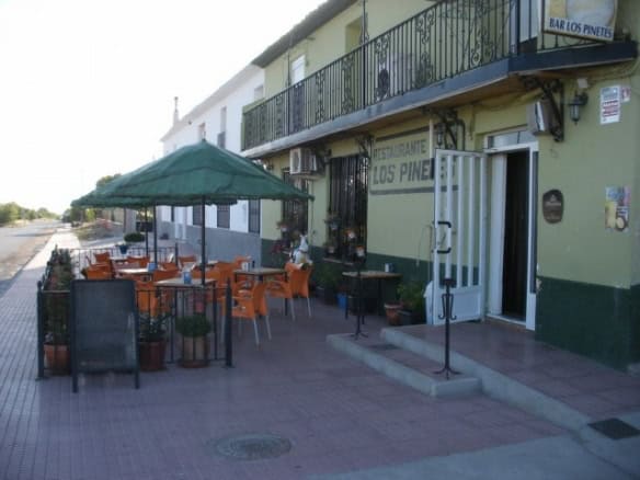 Traditional Spanish restaurant exterior in Las Vertientes, Granada, with outdoor seating and green a.