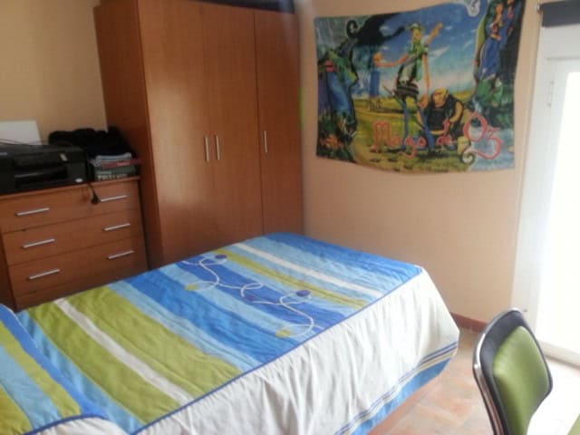 Cozy bedroom with colorful bedding and artwork in Las Vertientes, Granada.
