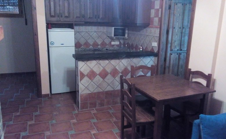 Kitchen and dining space in Gor, Granada with tiled floors and wooden furniture.