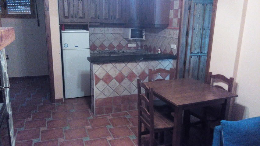 Kitchen and dining space in Gor, Granada with tiled floors and wooden furniture.
